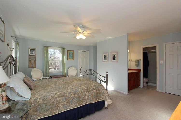 11525 Pine Cone Court Reston, VA 20191 - Photo 17 of 30 a bedroom with a large bed and a chandelier
