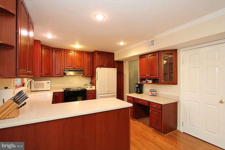 11525 Pine Cone Court Reston, VA 20191 - Photo 9 of 30 a kitchen with stainless steel appliances a sink a stove a refrigerator cabinets and a center island