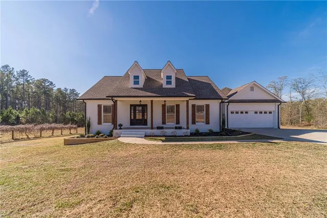 a front view of a house with a garden and swimming pool