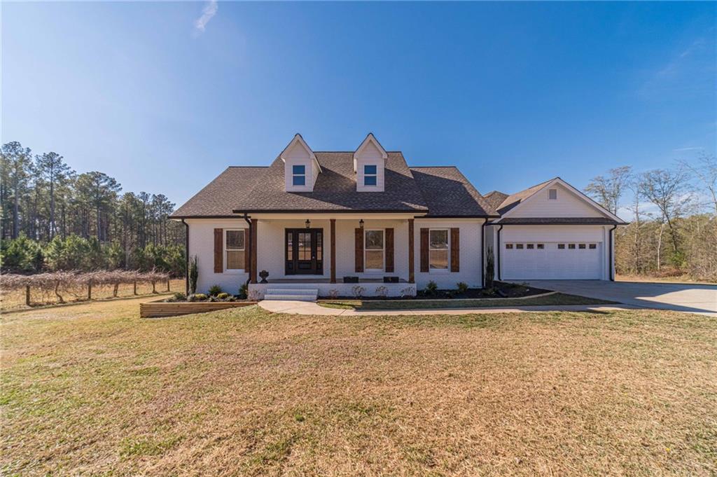 a front view of a house with a garden and swimming pool