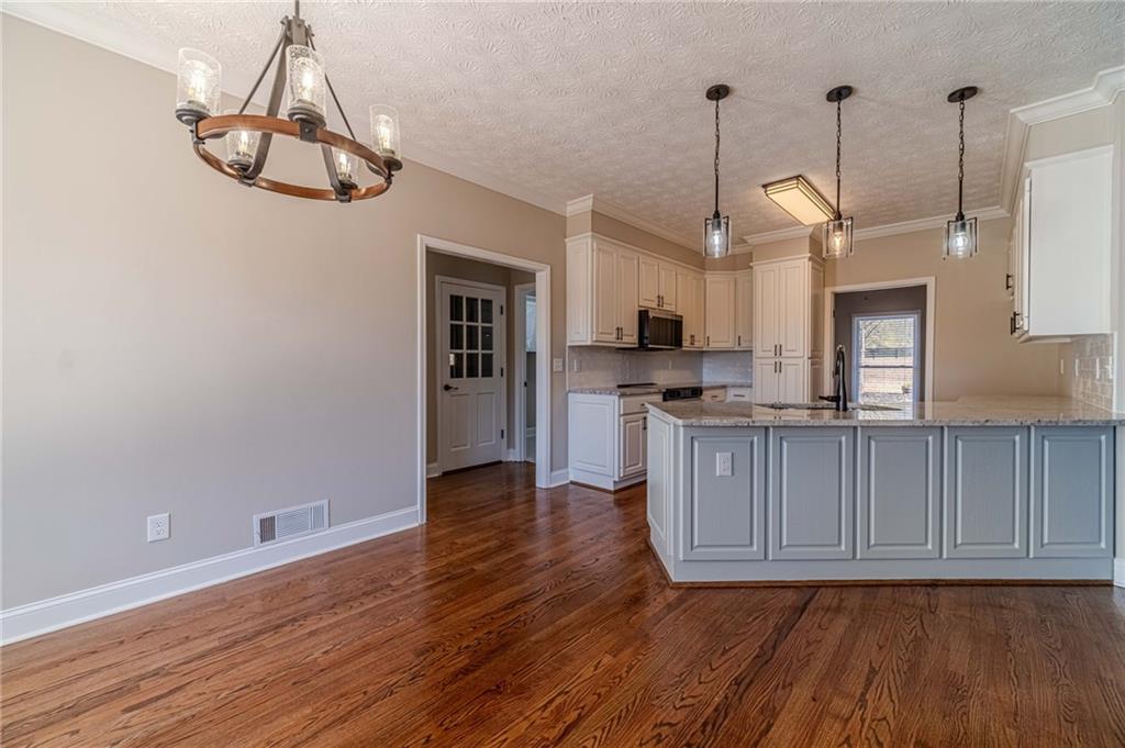 710 Youth Jersey Road Monroe, GA 30655 - Photo 12 of 53 a kitchen with stainless steel appliances granite countertop a refrigerator a stove and a wooden floors