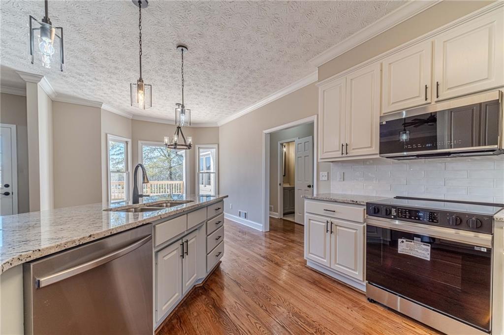 710 Youth Jersey Road Monroe, GA 30655 - Photo 18 of 53 a kitchen with stainless steel appliances kitchen island granite countertop a stove a sink and a microwave