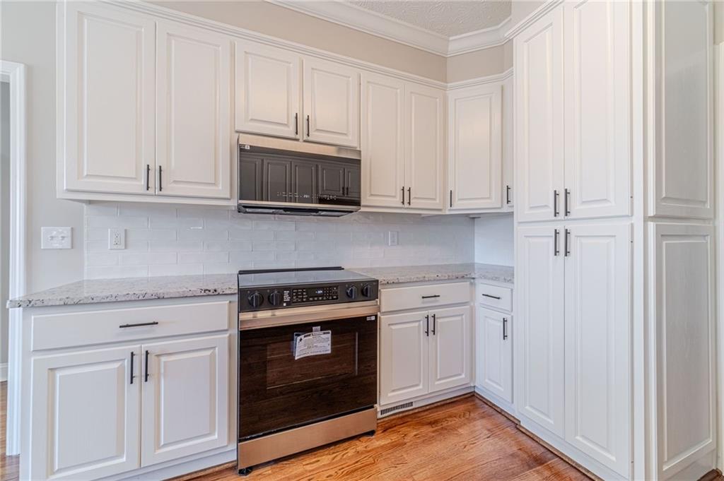 710 Youth Jersey Road Monroe, GA 30655 - Photo 19 of 53 a kitchen with white cabinets and stainless steel appliances