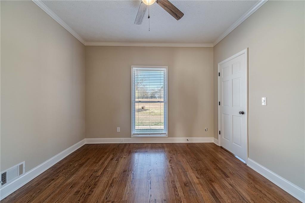 710 Youth Jersey Road Monroe, GA 30655 - Photo 20 of 53 an empty room with wooden floor chandelier fan and windows