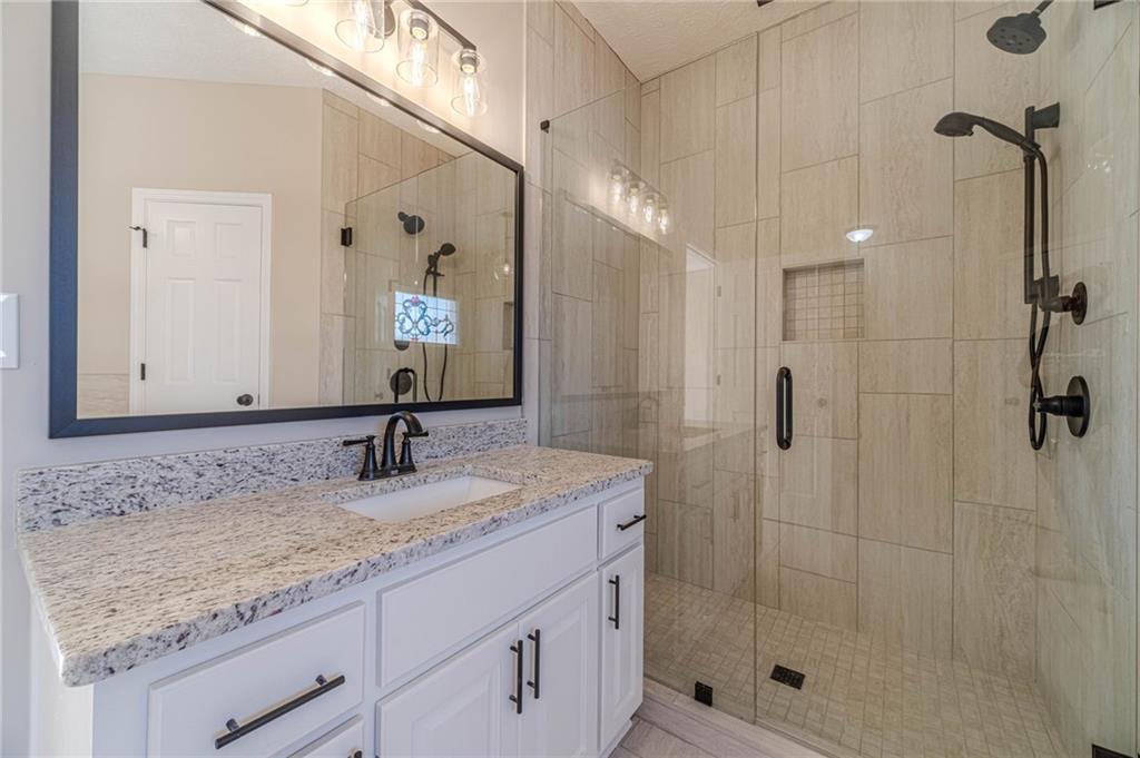 710 Youth Jersey Road Monroe, GA 30655 - Photo 30 of 53 a bathroom with a granite countertop sink a mirror and shower