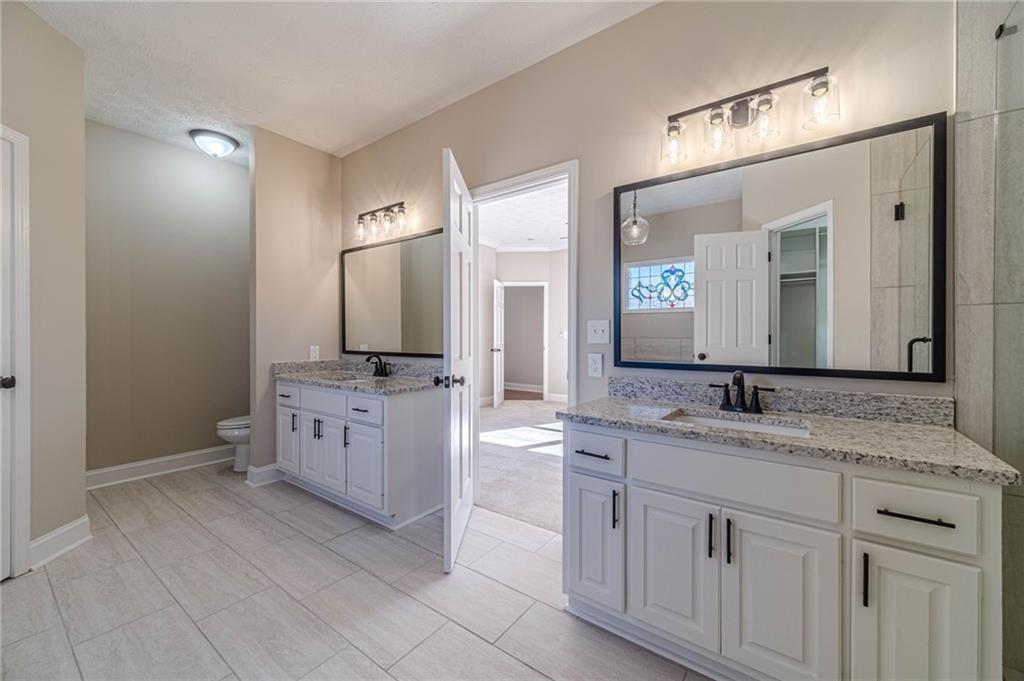 710 Youth Jersey Road Monroe, GA 30655 - Photo 35 of 53 a spacious bathroom with a granite countertop sink and a mirror