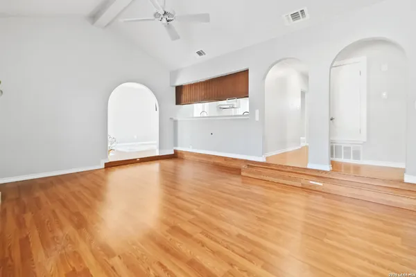 a view of empty room with wooden floor