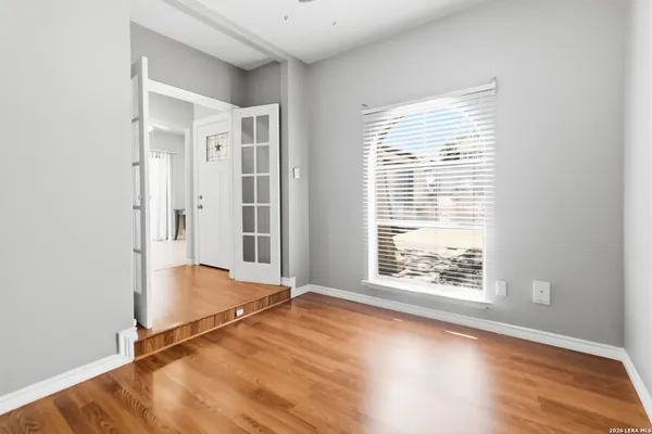 an empty room with wooden floor and windows