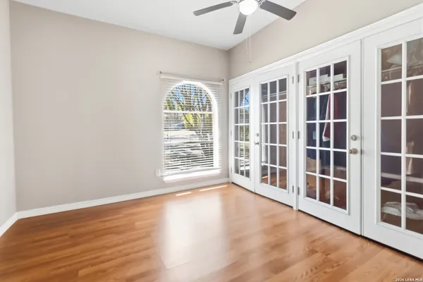 a view of an empty room with a window and wooden floor