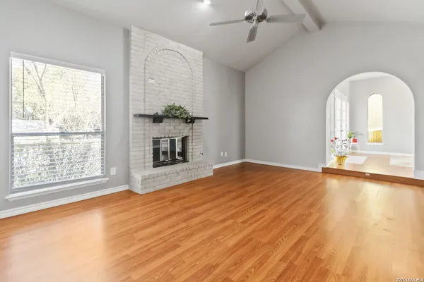 a view of empty room with a fireplace and wooden floor