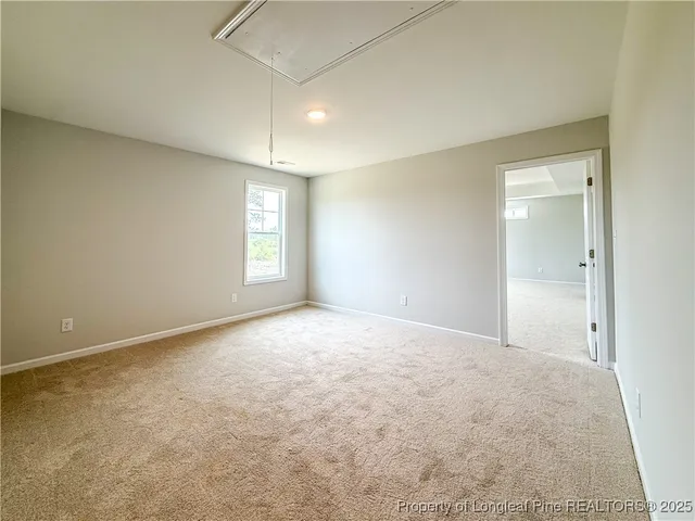 an empty room with windows and ceiling fan