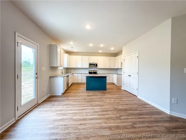a kitchen with granite countertop a refrigerator and a stove top oven