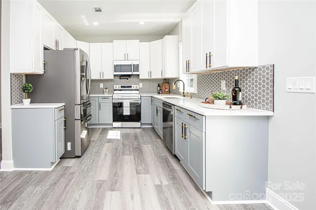 a kitchen with stainless steel appliances a stove refrigerator sink and cabinets