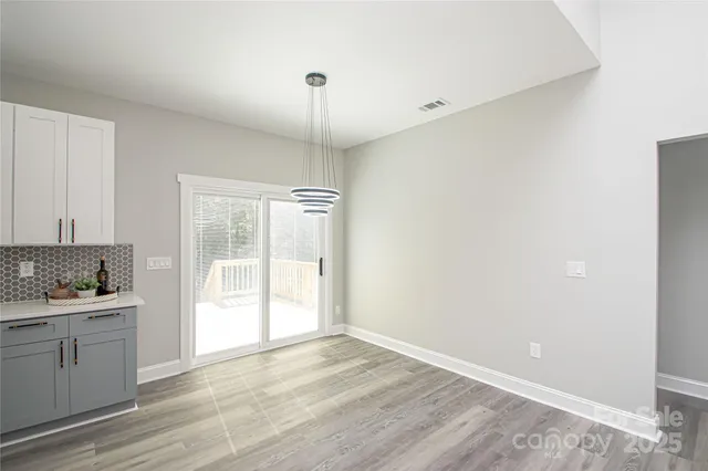 a view of a kitchen with a sink and dishwasher with wooden floor