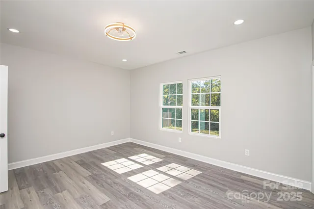 an empty room with wooden floor and a window