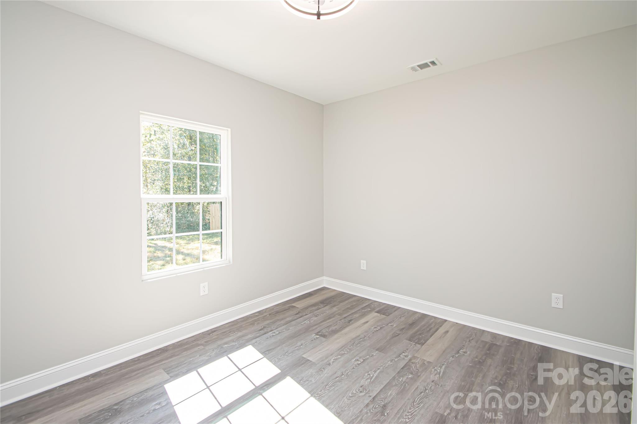 728 Sugar Plum Road Chester, SC 29706 - Photo 33 of 47 an empty room with wooden floor and windows