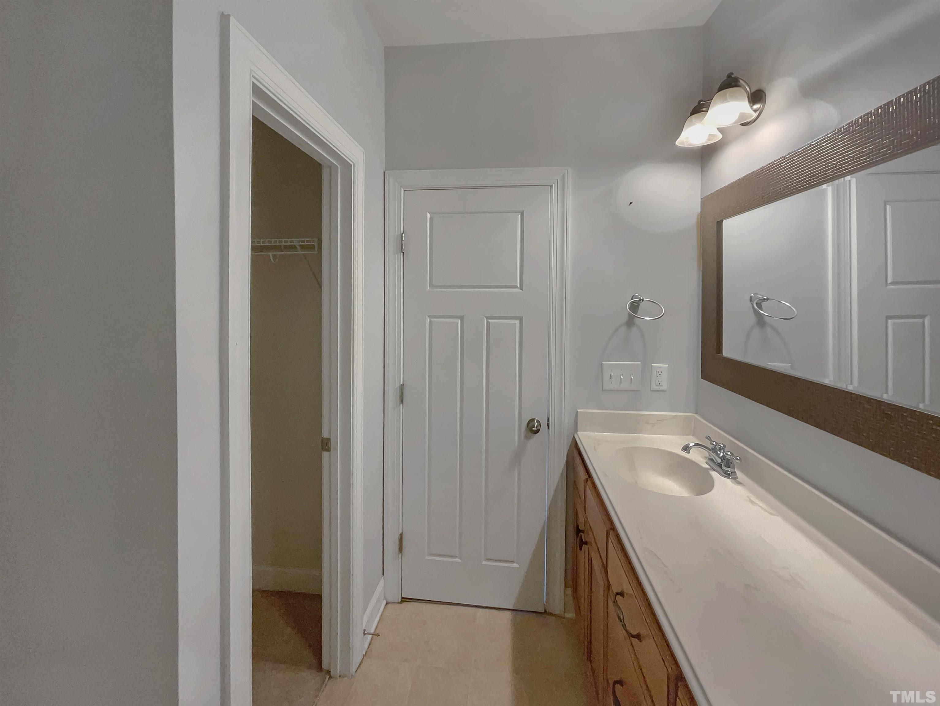 3953 Amelia Park Drive Raleigh, NC 27606 - Photo 13 of 17 a bathroom with a sink a vanity and a mirror