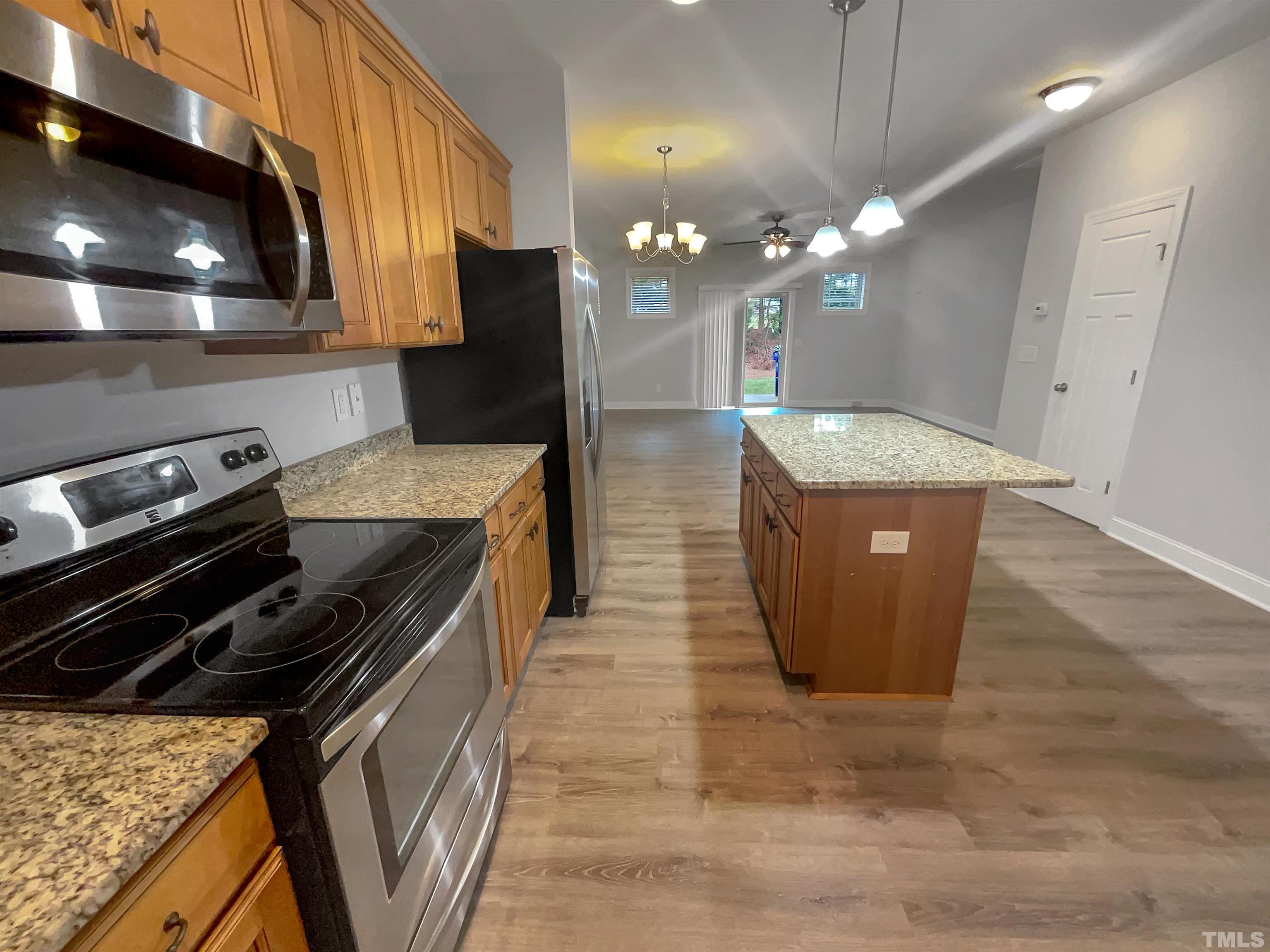 3953 Amelia Park Drive Raleigh, NC 27606 - Photo 4 of 17 a kitchen with stainless steel appliances granite countertop a sink a stove and a wooden floors