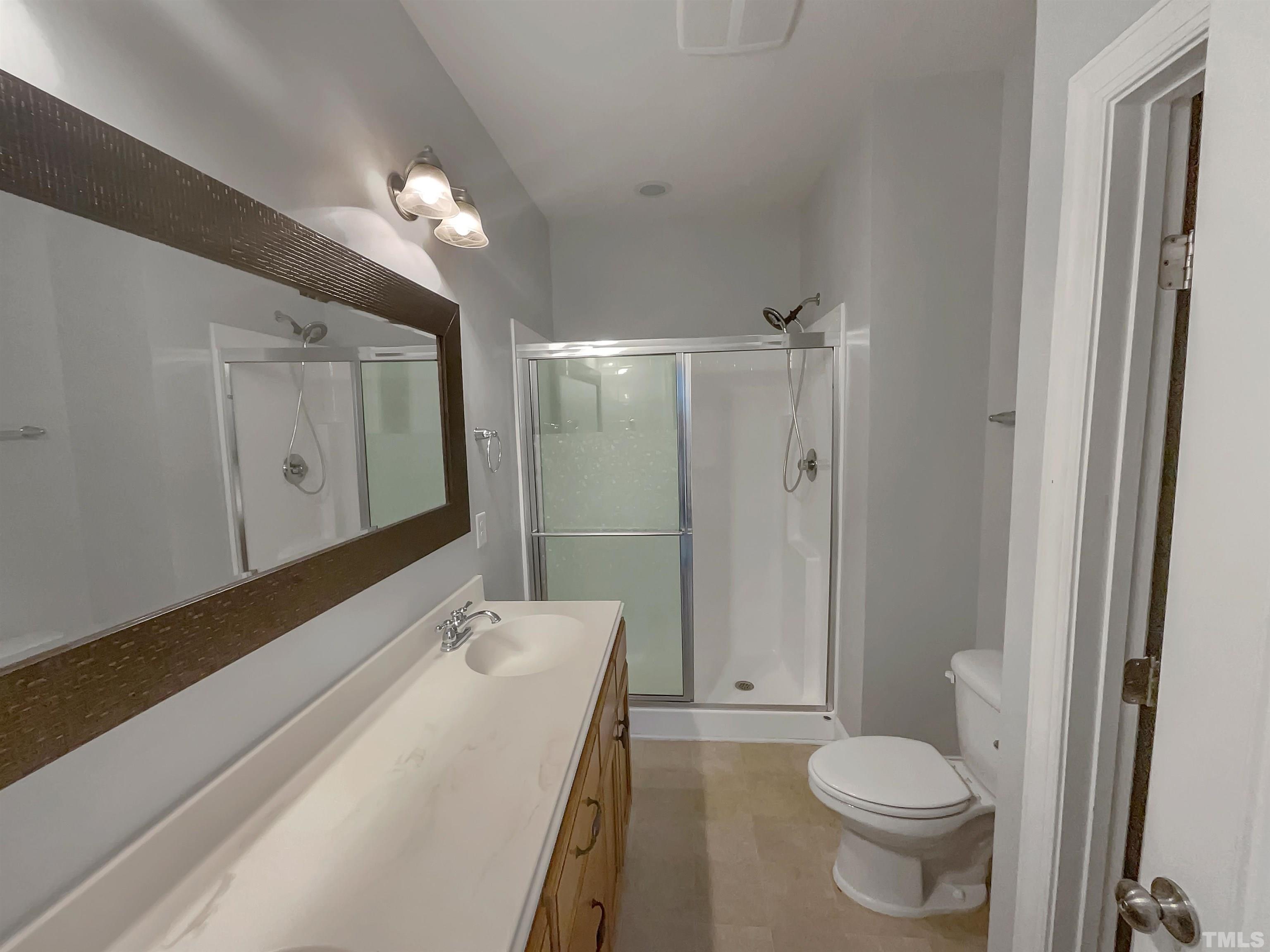 3953 Amelia Park Drive Raleigh, NC 27606 - Photo 6 of 17 a bathroom with a sink a toilet a large mirror and shower