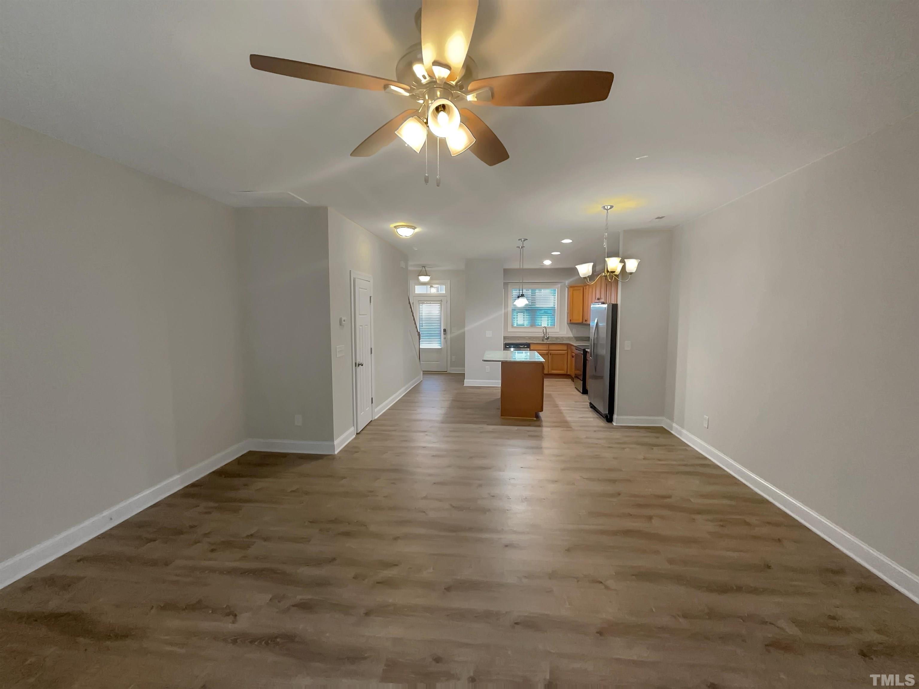 3953 Amelia Park Drive Raleigh, NC 27606 - Photo 8 of 17 a view of a livingroom with a ceiling fan and kitchen view