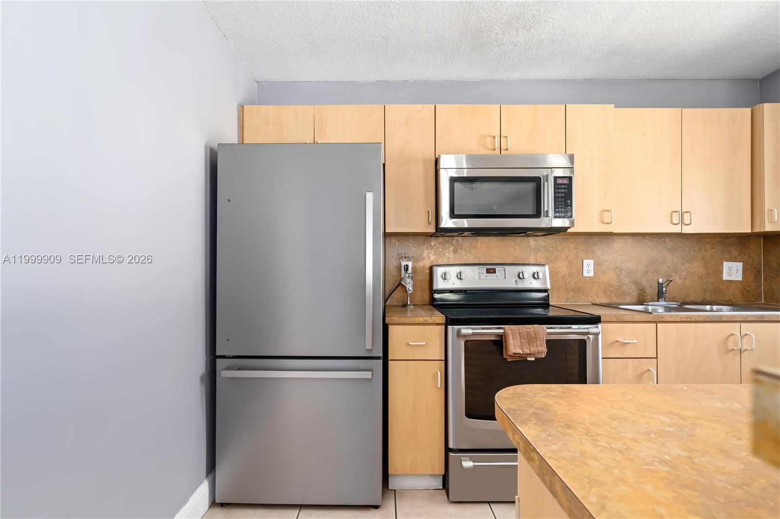760 Northwest 80th Street, Unit 760 Miami, FL 33150 - Photo 4 of 32 a kitchen with a refrigerator and a stove top oven