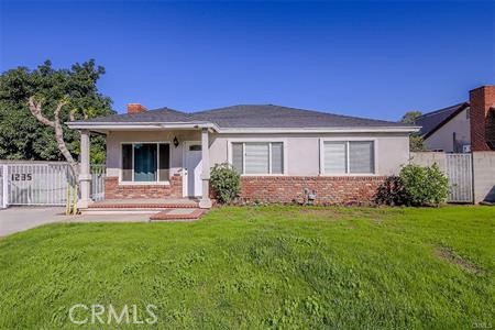1235 West San Bernardino Road Covina, CA 91722 - Photo 3 of 27 a front view of a house with a yard and garage