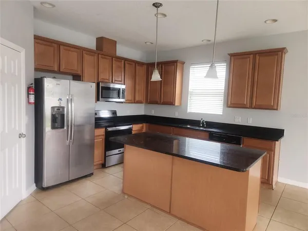 a kitchen with granite countertop a refrigerator and a sink