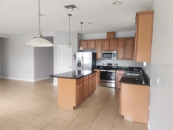 a kitchen with stainless steel appliances granite countertop a stove a sink and a microwave