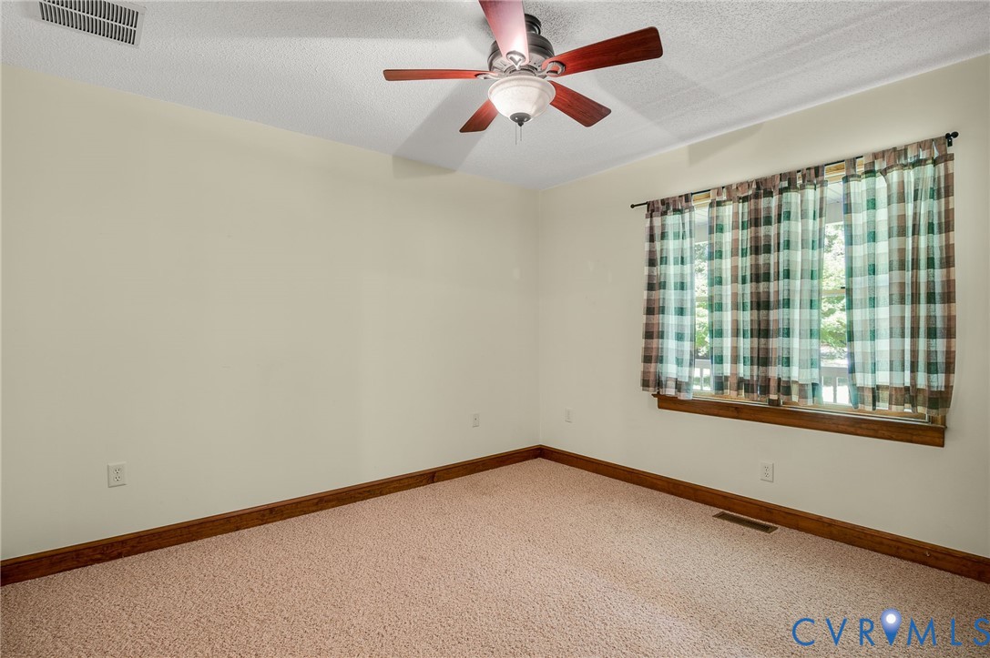 6724 Claiborne Road Sutherland, VA 23885 - Photo 6 of 33 Spare room with carpet floors, a ceiling fan, and