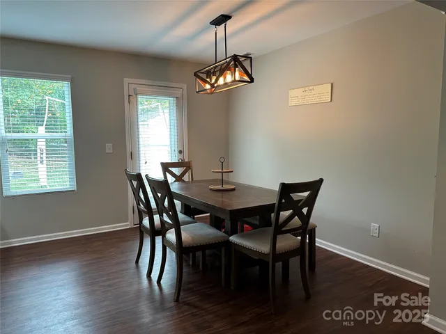 a dining room with furniture window and wooden floor