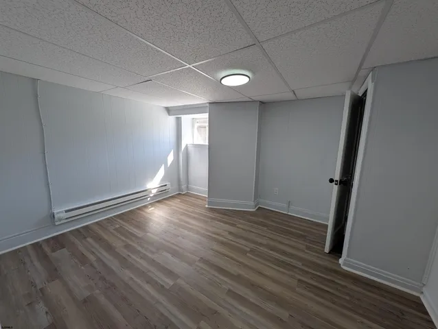 an empty room with wooden floor and window
