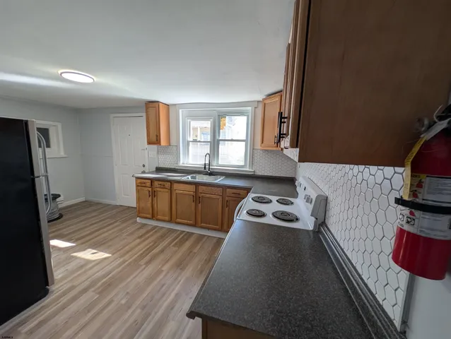 a kitchen with granite countertop a stove a sink and a refrigerator