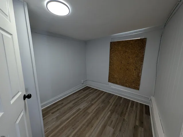 a view of small space with wooden floor and a window