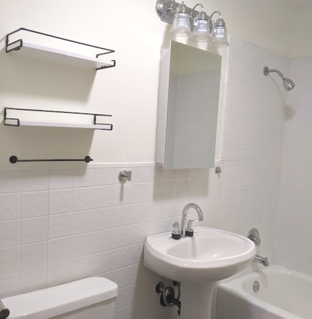 423 Grand Boulevard, Unit 423 Wauconda, IL 60084 - Photo 6 of 14 a bathroom with a sink a toilet and shower