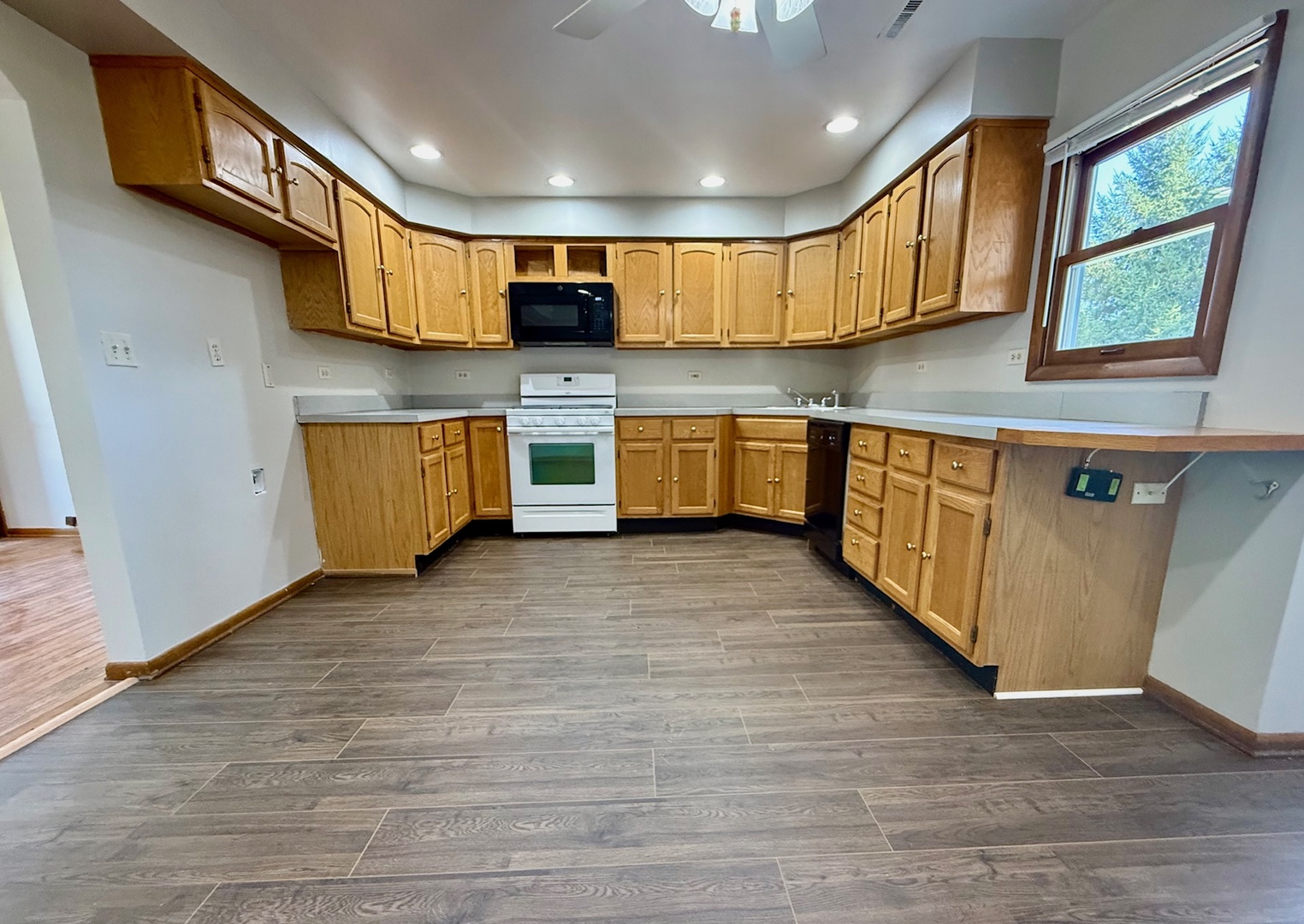 707 Sunset Circle Streamwood, IL 60107 - Photo 10 of 17 a kitchen with stainless steel appliances wooden cabinets a stove a sink and a microwave