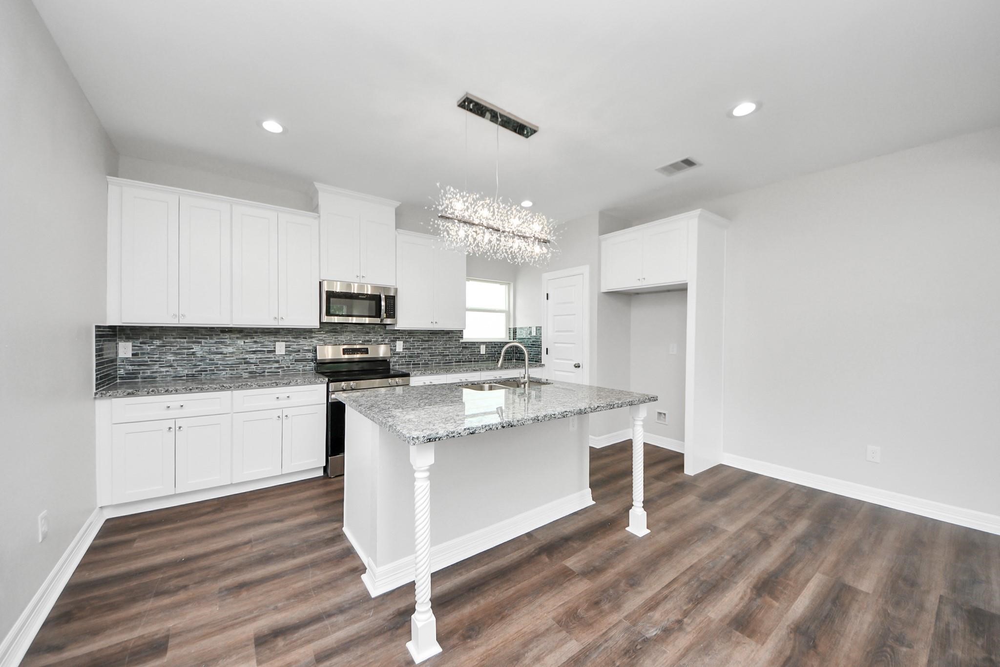 418 North 4th Street Beasley, TX 77417 - Photo 9 of 29 a kitchen with a sink cabinets and wooden floor