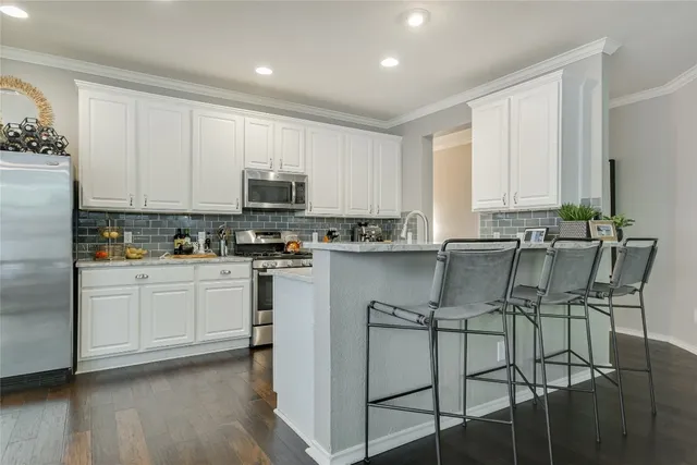 a kitchen with stainless steel appliances granite countertop a stove a sink a microwave and a refrigerator