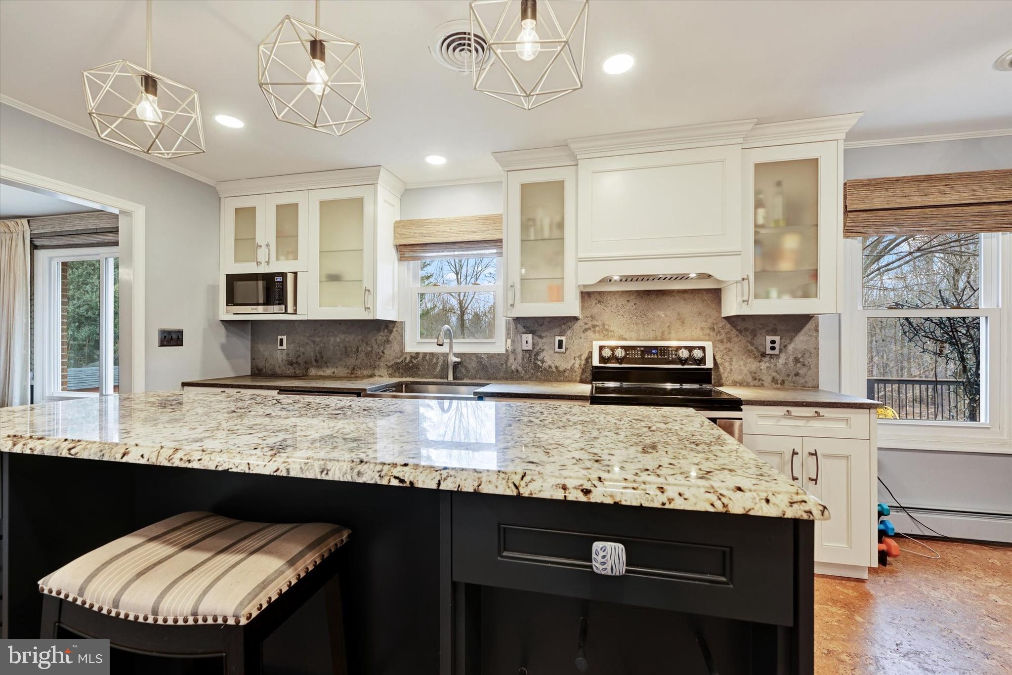 13324 Manor Road Baldwin, MD 21013 - Photo 11 of 34 a kitchen with granite countertop a sink a stove and a wooden cabinets