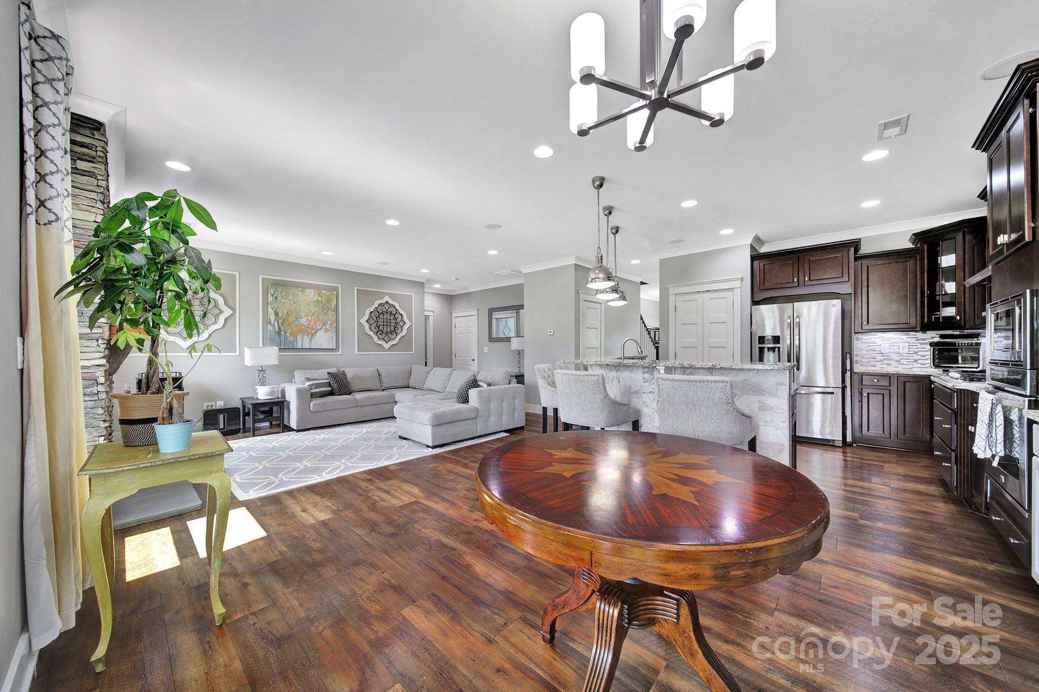 2015 Knocktree Drive Indian Trail, NC 28079 - Photo 12 of 45 a living room with dining table furniture a dining table with kitchen view and a potted plant