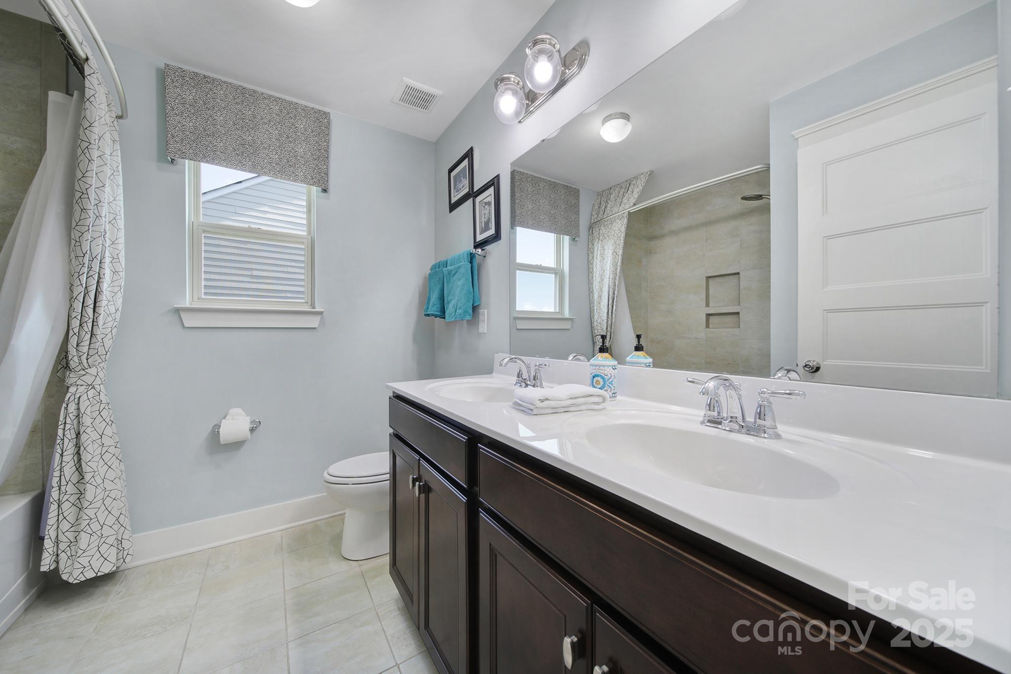 2015 Knocktree Drive Indian Trail, NC 28079 - Photo 28 of 45 a bathroom with a granite countertop sink a toilet and mirror