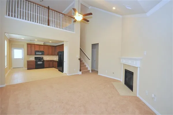 a view of a livingroom with a fireplace a chandelier a ceiling fan and wooden floor