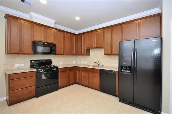 a kitchen with a refrigerator sink and cabinets