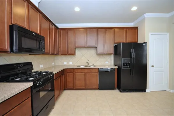 a kitchen with granite countertop stainless steel appliances and wooden cabinets