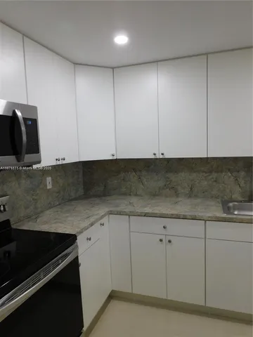 a view of a kitchen with white cabinets