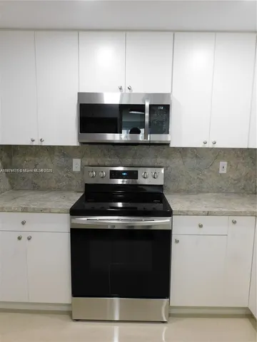 a stove top oven sitting inside of a kitchen