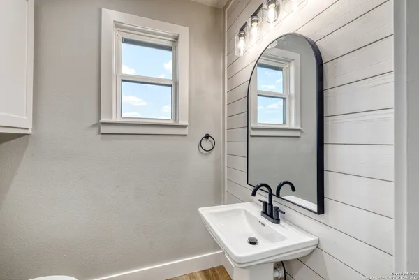 a bathroom with a sink a mirror and a window
