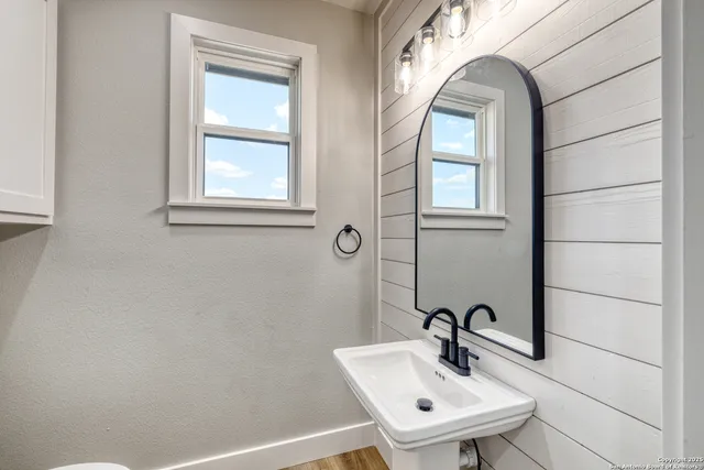 a bathroom with a sink a mirror and a window