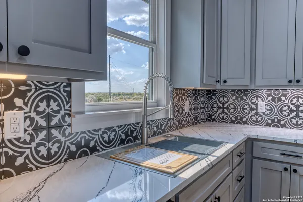 a kitchen with granite countertop white cabinets and stainless steel appliances