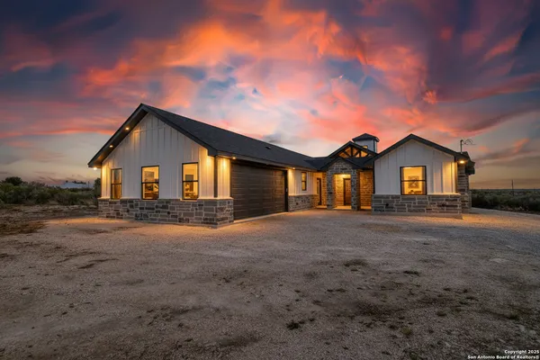 a view of a house with a big yard and large tree