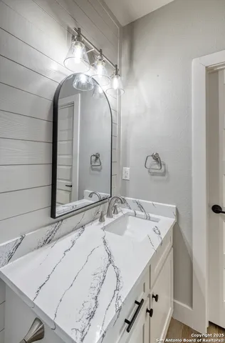a bathroom with a granite countertop toilet a sink and a mirror